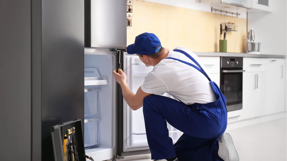 Technician repairing a refrigerator