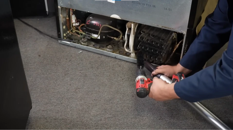 Cleaning the backside of a refrigerator near the defrost system