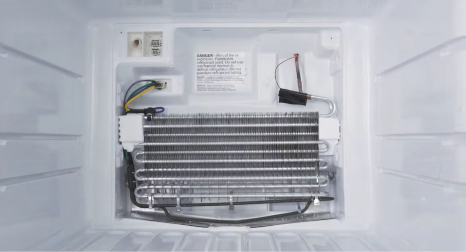 Refrigerator evaporator coil and defrost heater assembly